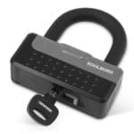 Schwarz-graues Kohlburg-Vorhängeschloss mit eingestecktem Schlüssel auf weißem Hintergrund.