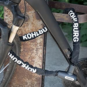 Ein Fahrrad, das mit dem schwarzen KOHLBURG langes Kettenschloss mit Zuklick-Mechanismus "Kopenhagen" an einem Metallgestell befestigt ist.