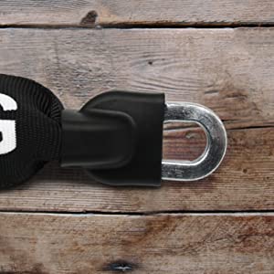 Nahaufnahme der Metallschlaufe des Extra-langen Sicherheits-Kettenschlosses "Helsinki", die an einem schwarzen Riemen befestigt ist und auf einer Holzunterlage ruht.