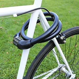 Auf einem weißen Fahrrad, das auf einer Wiese abgestellt ist, ist das "Bordeaux" lange massive Kabelschloss mit Zahlenkombination um den Rahmen gewickelt.