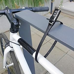 Ein weißes Fahrrad ist an einer grauen Schiene mit dem schwarzen Extrem leichtes Zahlenschloss "Valencia" befestigt.