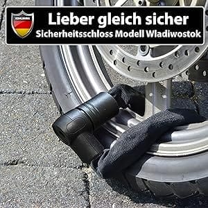 Ein mit dem Massiven Sicherheitsschloss "Wladiwostok" gesichertes Fahrradrad auf dem Bürgersteig, darüber ein deutsches Sicherheitszeichen.