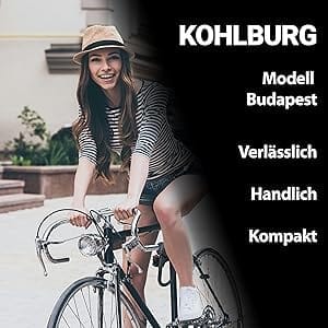 Lächelnde Frau mit Hut fährt auf einem Fahrrad; Text: "KOHLBURG Leichtes Sicherheits Bügelschloss Budapest - Verlässlich, handlich, kompakt".