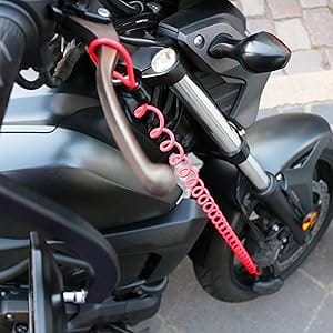 Nahaufnahme eines schwarzen Motorrads mit dem Sicheres Motorradschloss "Prag", einem roten Spiralschloss, das das Vorderrad am Lenker befestigt.